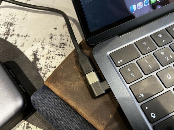A right-angle USB type C adapter (included) helps the cable escape out towards the back of the laptop, giving a clean setup.