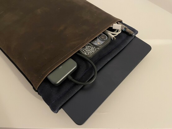 Top edge of the WaterField Folio Laptop Sleeve showing a USB Type-C dock, iPhone, Lightning Cable and pen peeking out.