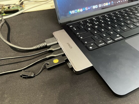 Side view of the Anker 7-in-2 hub plugged into a MacBook Air. Cables snake off the left edge of the picture.