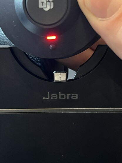 The Jabra Engage 55 just above the dock, showing the tiny USB plug.