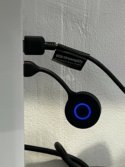 The Engage 55 dongle dangling out of my laptop. It clears the other USB port nicely without blocking it. The LED ring is lit up blue.