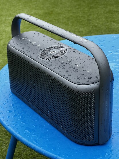 The motion X600 sat outdoors on a round, blue table in the rain. It’s covered in water droplets.