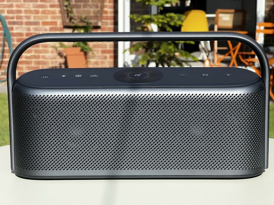 The soundcore Motion X600 sat on a grey table outdoors.