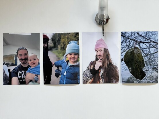 Four A4 printouts sellotaped to my kitchen wall. It’s a candid phone picture of me and C. Then X and mum. Me in a pink beanie. And a photo of a frosty leaf I took over winter.