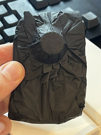 The Belkin 10w car charger, wrapped in creased, black paper. It’s quite messy.