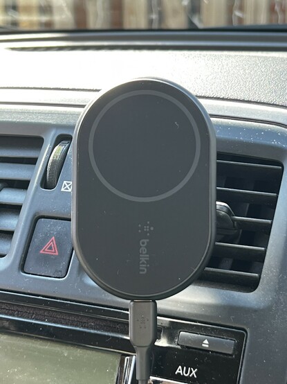 The oval Belkin 10w charging pad stuck into a car air vent.