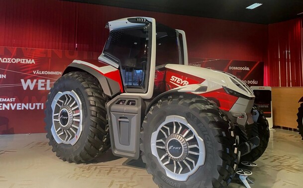 An official photo of Steyr Tractor’s “Konzept” electric tractor. It quite a bold angular design that very much looks like a tractor but might have things like in-hub motors and accommodations for a larger, perhaps even hot-swappable battery. It’s grey, white and red.