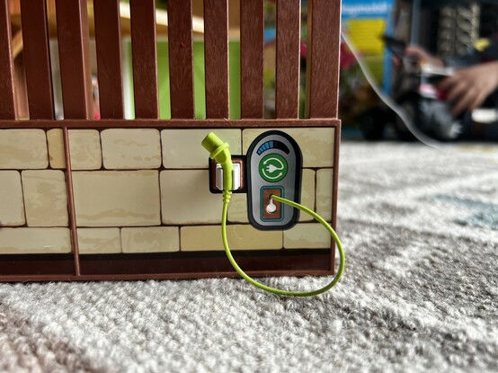 A little EV charger on the side of the farm, complete with a charging cable and holder- which is a repurposed door hinge clip. Nice part re-use!