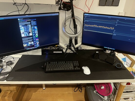 A photo of my desk showing a fairly tidy (for me) setup with the Belkin Triple Display dock driving two 4K displays. The left display shows my website which is very lost in the middle. The right display shows Grafana graphs plotting data from my weather station.