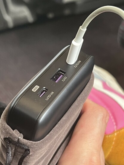 The top of UGREEN’s power supply showing the USB C and A ports. Two ports are unoccupied revealing their purple colour coding inside. A third port has a white lighting cable trailing off the right-hand edge of the picture. One of the two USB type-C ports is marked 100W, as a reminder where to plug in a laptop. There’s no tactile indication which port this is.
