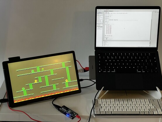 An external 14” HDMI display sat alongside a laptop. It’s snowing a snakes and ladders style retro game, with the laptop showing the Python code - or some of it at least - behind the game. A little black PCB trails in front of the display, with a Pico W soldered to it. It’s clearly running the code and proving the HDMI signal.