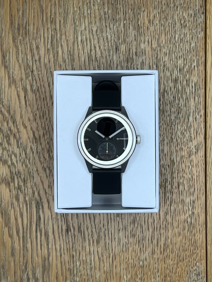 The box opened and presenting the Watch wrapped around a plain white, two piece cardboard insert. No fancy plush interior. The watch speaks for itself.