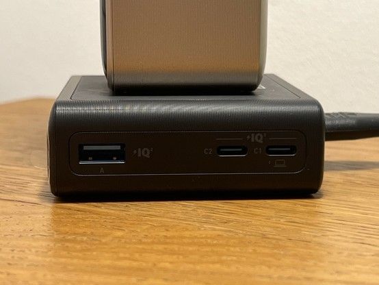 A close-up of a black device with various sockets labeled A, C1, and C2, featuring USB and USB-C ports, with 