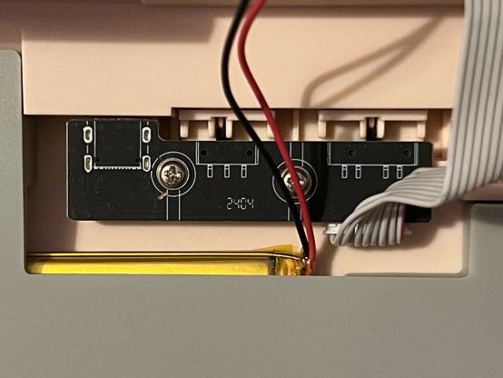 A close-up of the USB and switch daughter-board in the Epomaker Shadow S. It’s connected by a very unconvincing looking IDE-style ribbon. The silk indicates there are two switches with two and three positions and a reinforced USB type C port. A LiPo battery peeks in at the bottom, its red and black wires cutting across the photo.