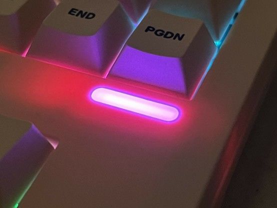 Close-up of a mechanical keyboard with RGB backlighting highlighting the keys marked 