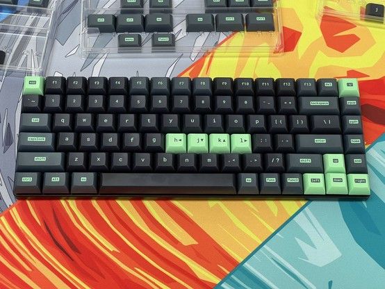 A mechanical keyboard with black and green keycaps on a colorful desk mat.