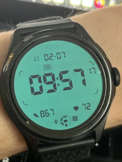 The same smartwatch showing the same date and time but the display colours have inverted and the text looks faded. It’s a low power TN display being backlit by the OLED and the OLED watch face matches it perfectly.