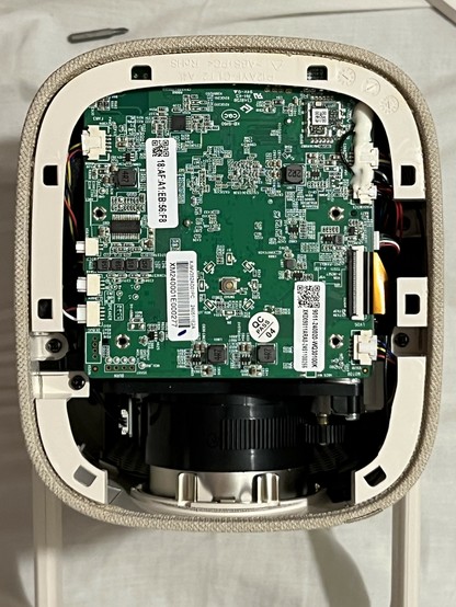 Close-up view of the internal components of an electronic device, showing a green circuit board with various electronic parts, wires, and connectors. At least eight connectors are visible with hints of two tiny antenna connectors.