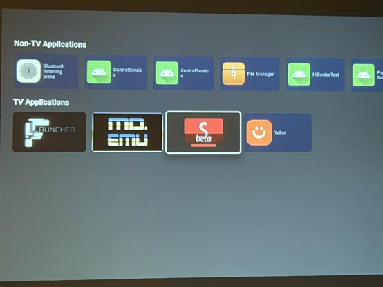 Photo of a projector screen displaying various application icons categorized into 