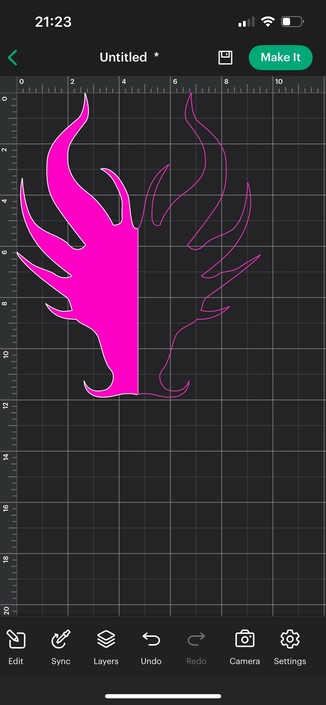 Cricut Design Space on a mobile phone showing a pink, dragon shape on a grid background. Half the shape is marked as a cut and the other is displayed as a guide. Various editing tools are available at the bottom of the screen.