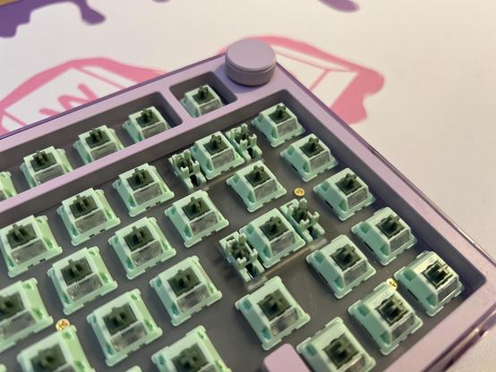 An overhead view of a mechanical keyboard showing green switches with matching green stabilisers.