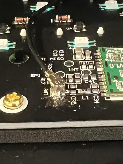 An SMA messily connector soldered back into its place on a PCB. A green wireless module is just peeking in on the right hand side.