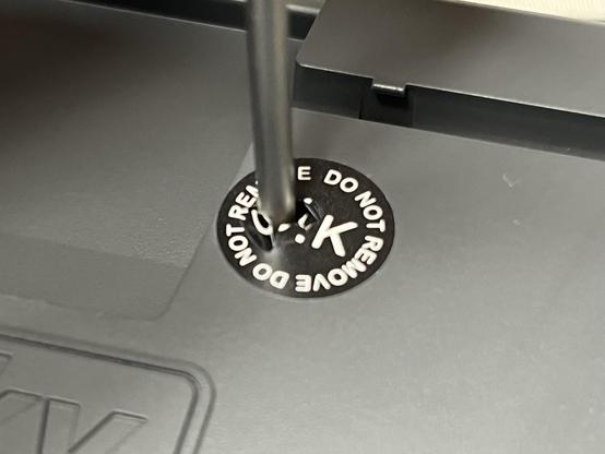 A “do not remove” sticker punctured by a screwdriver.