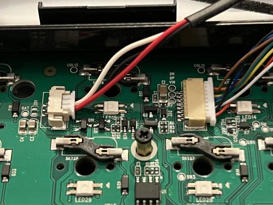 A closeup of a mechanical keyboard PCB showing JST connectors for the battery and USB connector daughter board. A hex screw post sticks to through the PCB, looking distinctly undersized for its job.