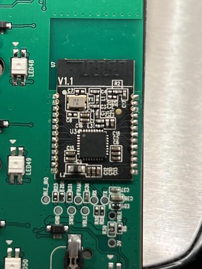 Closeup of a black, unlabelled PCB RF module with castellated edges soldered down to a green PCB.