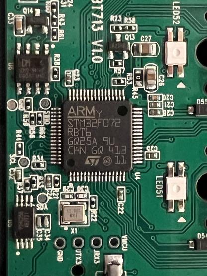 Closeup of an STM32F072 and supporting components on a green PCB