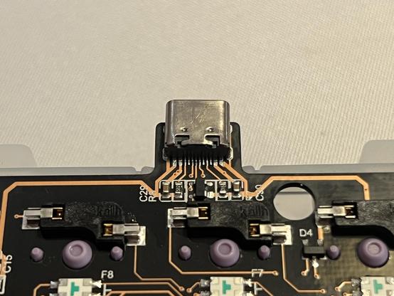 Closeup of the USB C connector on the PCB. Transparent resist reveals the copper traces.