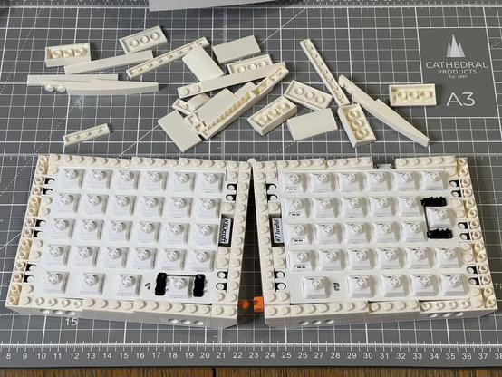 The bottom half of a split keyboard still being assembled from LEGO style bricks.