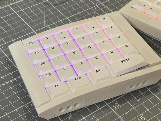 The left hand side of the completed split keyboard with purple and pink backlighting peeling between the keys.