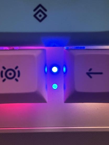 A very bright blue status LED shining between the left arrow key and a modifier.