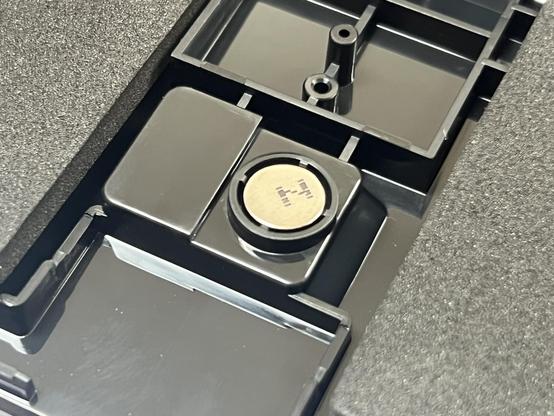 A little round magnet glued on top of a suspiciously wireless dongle shaped recess.