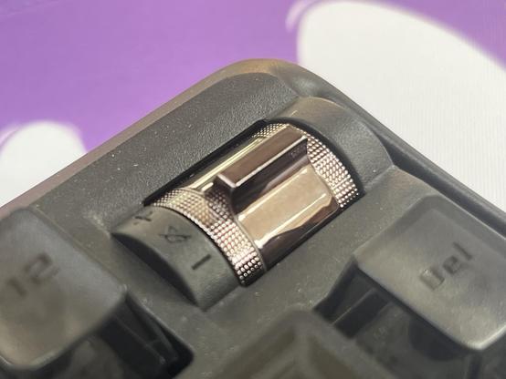 A little shiny volume rocker switch peeking out of the keyboard.