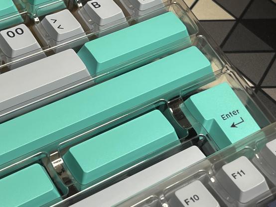 A closeup of vibrant teal space bars and an ISO enter key.