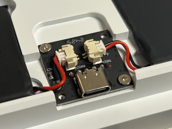 A little PCB with a USB Type-C port and two JST connectors for batteries in each side of the keyboard base.