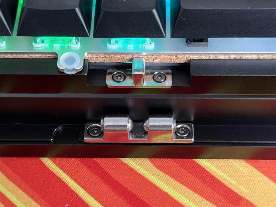 The two halves of a cabinet ball catch screwed to the top and bottom shells of a mechanical keyboard case.