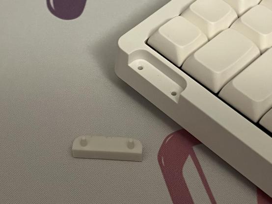 A small rubber blanking plate removes from the edge of the keyboard revealing screw holes for the strap to be mounted.