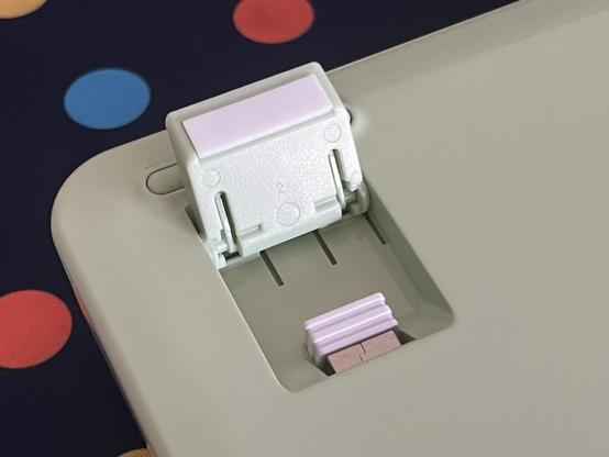 A closeup of the flip out food underneath a plastic keyboard. A USB dongle peeks out from a recess next to it, concealed in the foot-well.