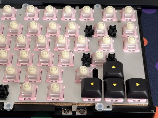 A mechanical keyboard with most keycaps removed and fully populated with pink switches.