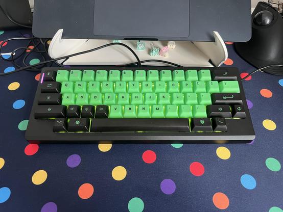A compact HHKB layout keyboard with only two keys flanking the spacebar at each side and no F row. It has bright green and black keycaps.