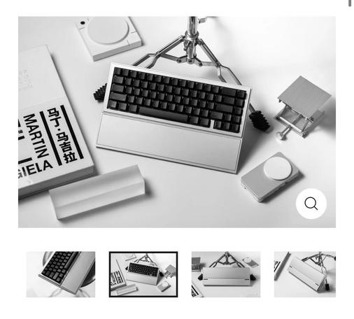 A series of very fancy, staged photographs featuring a very refined steel grey keyboard with blank black keycaps and an attached wrist rest.
