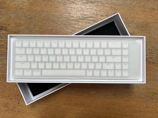 A compact low profile keyboard wrapped in protective paper and nestled in its box.