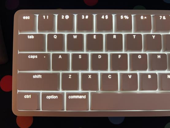 White keycaps lit with white light from underneath, the shine through legends glowing uniformly and legibly.