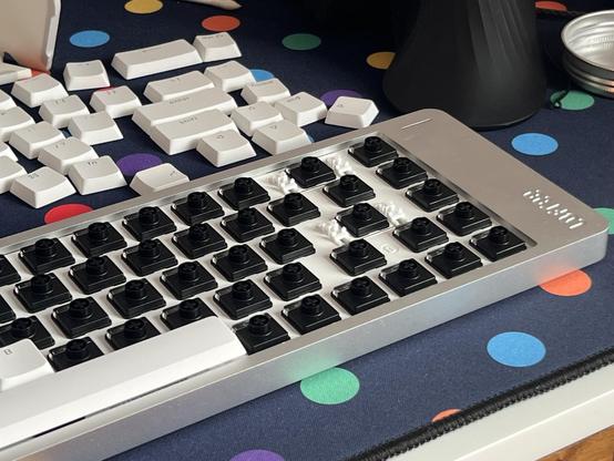 A silver, low profile keyboard with keycaps removed and a full set of black low profile switches installed.