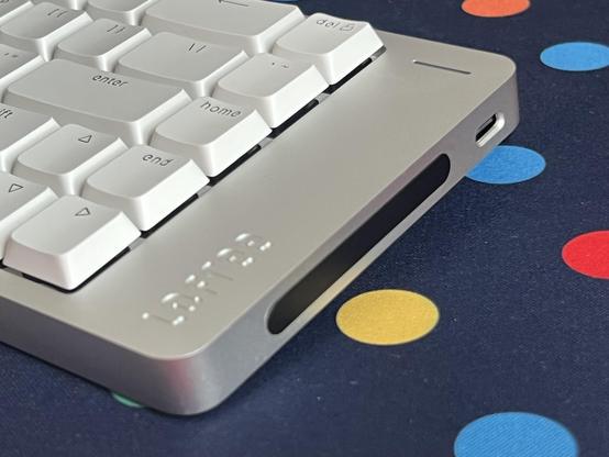 The edge of the Lofree Flow 2 keyboard, revealing a black plastic touch sensitive bar about an inch and a half in length. Towards the back of the keyboard is also a side-mounted USB type-C port.