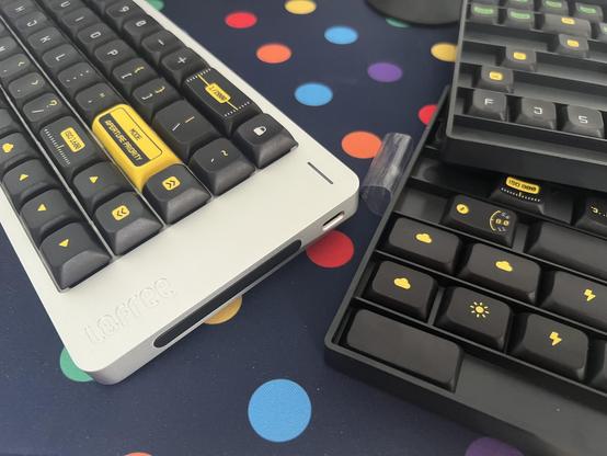 A low profile, compact silver keyboard populated with low profile, softly rounded keycaps with a black and yellow, Leica camera inspired theme.