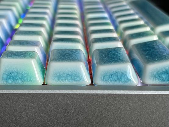 A side view looking down the rows of keys on a mechanical keyboard, showing their tops are generally either flat or slightly protruding.